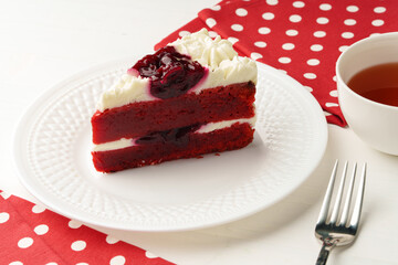 Piece of red velvet cake on white table