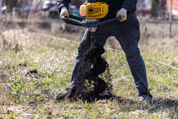 Worker digs the ground with a gasoline blower in the garden