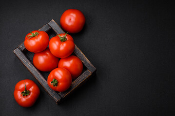 Delicious fresh juicy tomatoes on a dark concrete background
