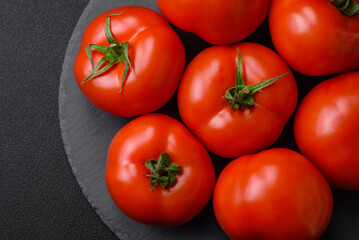 Delicious fresh juicy tomatoes on a dark concrete background