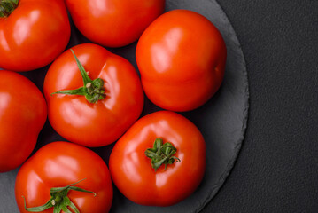 Delicious fresh juicy tomatoes on a dark concrete background