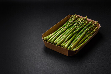 Delicious fresh sprigs of asparagus on a dark textured background