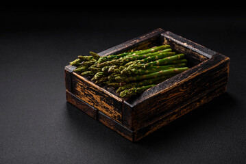 Delicious fresh sprigs of asparagus on a dark textured background