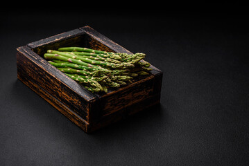 Delicious fresh sprigs of asparagus on a dark textured background