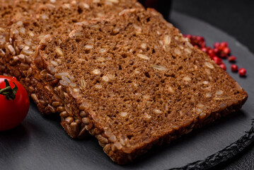 Fototapeta na wymiar Delicious fresh crispy brown bread with seeds and grains cut into slices