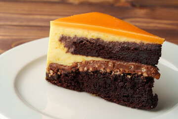 Delicious chocolate cake in white plate on wooden table background