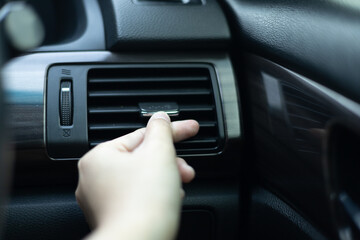 Close up woman hand is checking air conditioner in the car. Car cooling control button. hot air conditioner in car, heat and warm, checking air. over cooling or over heating in car.