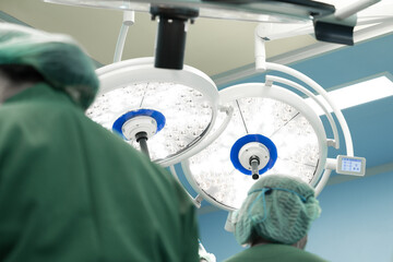 Surgery modern operating room with surgical lamp for emergency save lives.Medical team of surgeons working surgical intervention.Selective focus.