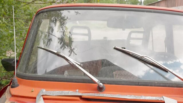 The wipers of the small red truck parked outside the house in Estonia