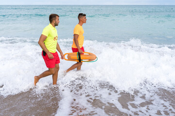 Obraz premium Lifeguards walking on the water of a beach