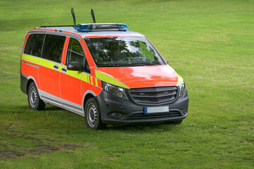 German emergency vehicle or fire engine on a meadow, red yellow marked van for transporting the...