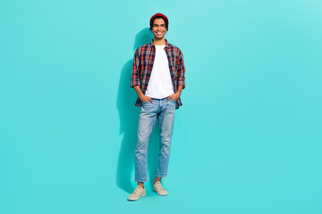 Fototapeta premium Full length photo of positive satisfied young person put hands pockets posing isolated on teal color background