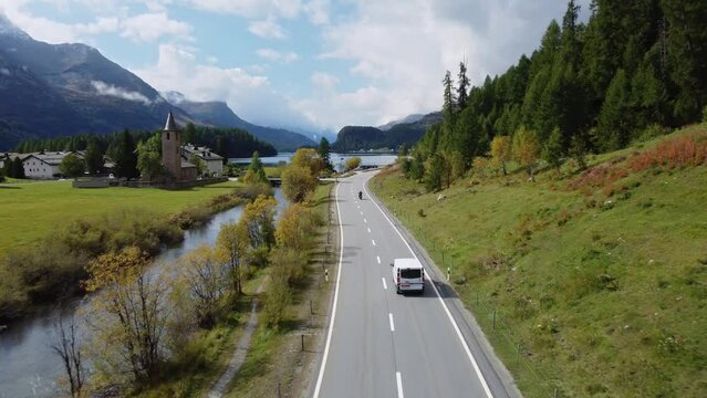 Sils Maria, Switzerland: Aerial drone footage on the road along lake Sils and village with its old church in the Engadin valley near St Moritz in Canton Graubunden in the Swiss alps in late summer. 