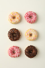 Fototapeta na wymiar Chocolate, white and pink donuts on white background, top view