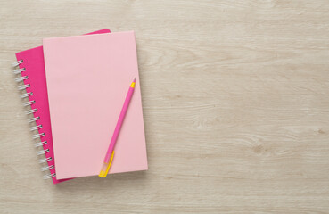 Notebooks with pen on wooden background, top view
