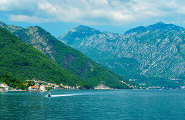 seascapes, a view of the Bay of Kotor during a cruise on a ship in Montenegro, a bright sunny day, mountains and small towns on the coast, the concept of a summer trip