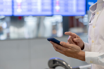 Business man using mobile phone to book plane ticket through online application, sitting on travel...