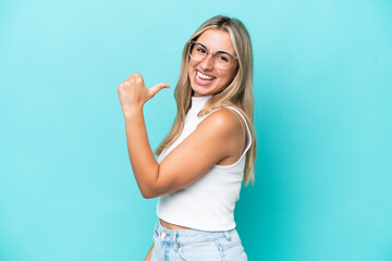 Fototapeta premium Young caucasian woman isolated on blue background proud and self-satisfied