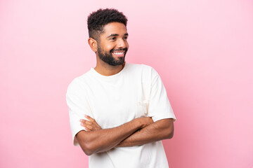 Young Brazilian man isolated on pink background happy and smiling