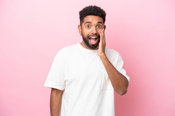 Young Brazilian man isolated on pink background with surprise and shocked facial expression