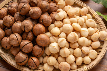 Roasted Macadamia nut in wooden plate on wooden background.