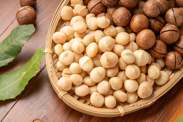 Roasted Macadamia nut in wooden plate on wooden background.