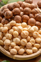 Roasted Macadamia nut in wooden plate on wooden background.