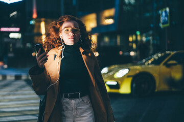 Successful woman using smartphone while waiting for a taxi outdoors.