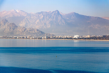 View of Konyaalti beach and Taurus mountains in the background in sunny winter day. Antalya, Turkey, January