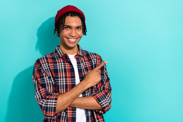Photo portrait of nice young guy point empty space representative agent dressed stylish checkered clothes isolated on cyan color background