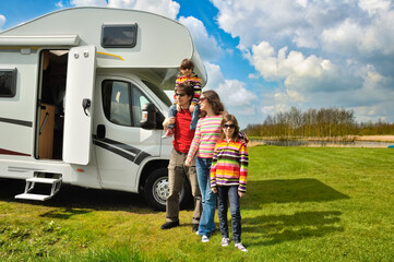 Family vacation, RV travel with kids, happy parents with children have fun on holiday trip in motorhome, camper exterior
