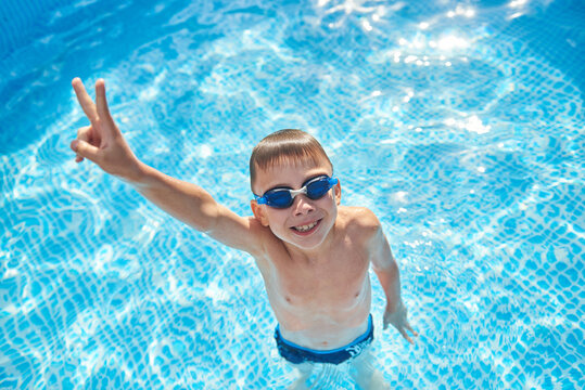 8 year old boy having fun in the home swimming pool