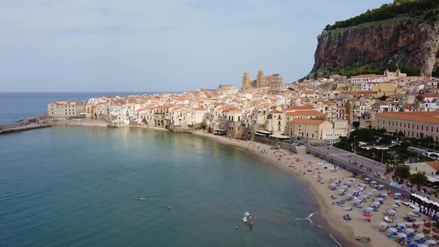 Cefalu, Italy: Aerial drone footage of the Cefalu medieval old town, famous for its Norman cathedral and cliff near Palermo in Sicily. Shot with a forward tilt down  motion. 