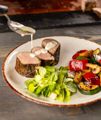 The cook pours sauce