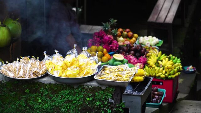 A local street stall selling BBQ grilled foods and fresh fruit on the island of Bali, Indonesia. Handheld static tele shot