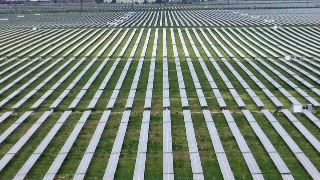 Sea of solar panels. Huge energy generation solar farm. Photovoltaic panels collect sunlight in USA. Aerial tilt up reveal of rows of solar arrays.