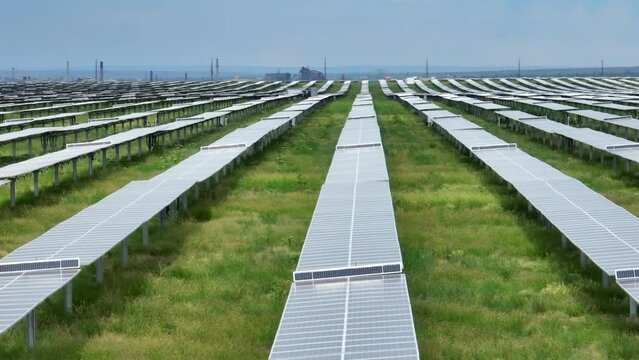 Solar farm. Aerial rising shot revealing never ending line of solar panels at energy plant. Renewable and clean energy sources replace outdated polluting plants.