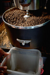 hands holding plastic dish for roasted whole grain coffee