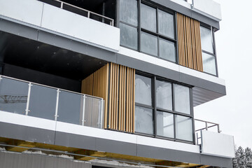 Condominium and apartment building with symmetrical modern architecture. Detail in modern residential flat apartment building exterior. Fragment of new luxury house and home complex