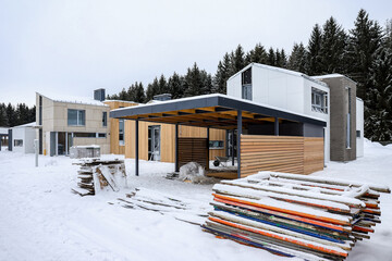 Modern house and parking under construction in a pine grove. Construction outside the city in nature, private territory in a magical forest