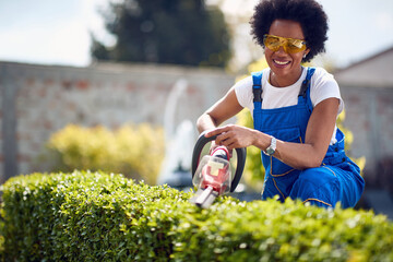 The Art of Hedge Trimming: Afro-American Gardener Crafting Green Masterpieces with Precision