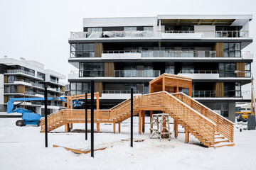 Construction of a modern new residential apartment house building complex in winter with outdoor facilities concept