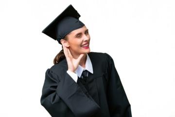 Young university graduate  caucasian woman over isolated background listening to something by putting hand on the ear