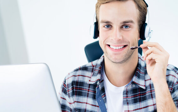 Can I help You? Male customer support phone operator in headset, in smart casual wear, with computer. Consulting and assistance, service call center concept image.