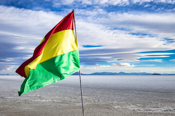 Scenery view of close-up bolivian flag on wild nature salt flat, scenic backgrounds. Landscape photo flag of Bolivia in natural salt desert wilderness. Bolivian landmarks concept. Copy ad text space