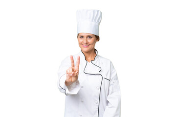 Middle-aged chef woman over isolated background smiling and showing victory sign