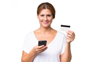 Middle-aged caucasian woman over isolated background buying with the mobile with a credit card