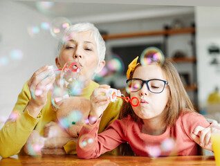 child grandparent granddaughter grandmother bubble soap blowing fun together girl grandchild family...