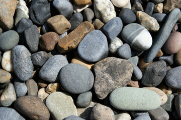 Stones of different sizes on the beach. Background texture.