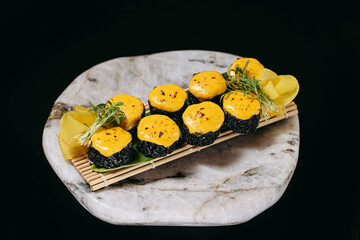 Black Baked sushi on a wooden board